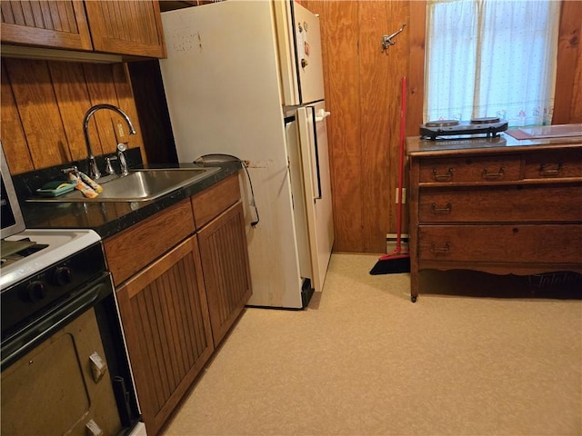 476 Musson Erwin Rd, Butternuts, NY 13843 - kitchen with freestanding refrigerator, range, brown cabinets, dark countertops, and a sink