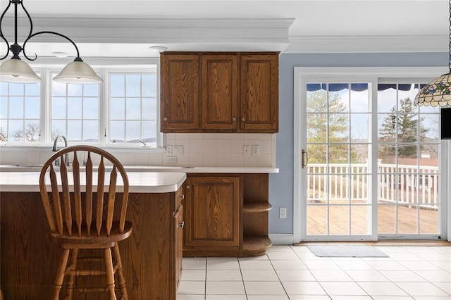 507 Hilltop Rd, Union, NY 13760 - kitchen featuring light countertops, tasteful backsplash, light tile patterned floors, ornamental molding, and brown cabinets