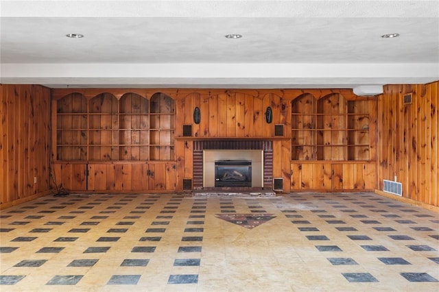 507 Hilltop Rd, Union, NY 13760 - unfurnished living room featuring built in features, wood walls, baseboards, and visible vents