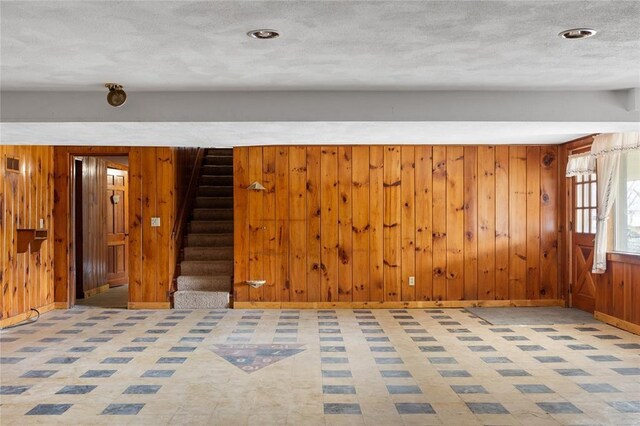 507 Hilltop Rd, Union, NY 13760 - empty room with wood walls, stairs, baseboards, a textured ceiling, and tile patterned floors
