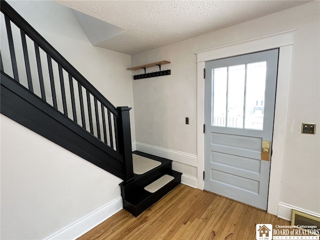 3514 Lake St, Ellicott, NY 14701 - entrance foyer with light wood-style floors, a textured ceiling, baseboards, and stairway