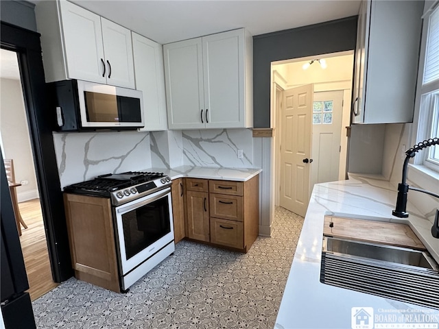 3514 Lake St, Ellicott, NY 14701 - kitchen featuring a sink, gas stove, white cabinets, decorative backsplash, and white microwave