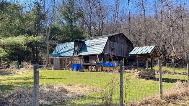 view of barn featuring a lawn and fence
