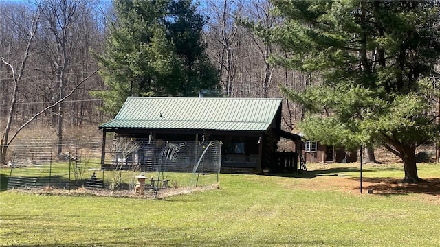 view of front of home featuring log exterior, a front lawn, and metal roof