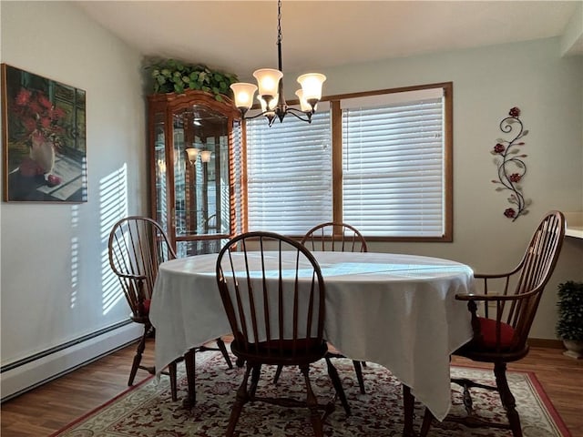 dining room featuring wood finished floors, an inviting chandelier, and a baseboard radiator