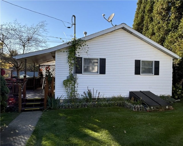 view of side of home featuring a lawn and a deck