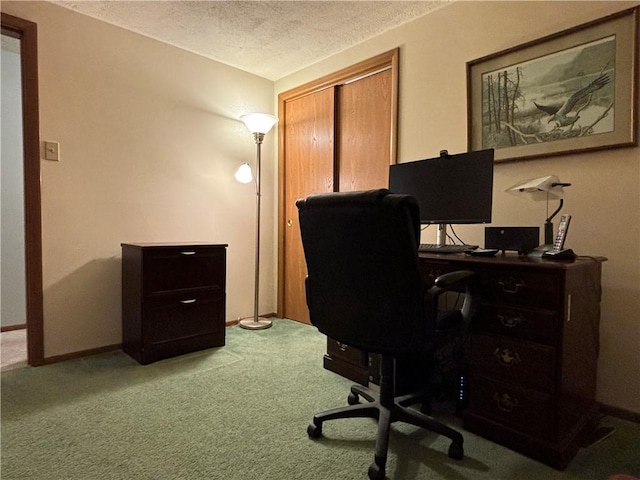 carpeted office featuring baseboards and a textured ceiling