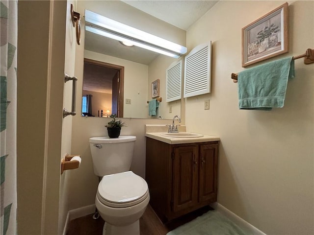 full bathroom featuring toilet, vanity, and baseboards