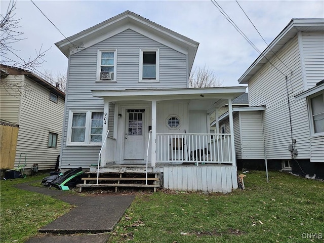 traditional-style house featuring a porch, a front yard, and cooling unit