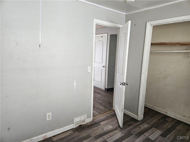 unfurnished bedroom with wood finished floors, visible vents, and baseboards