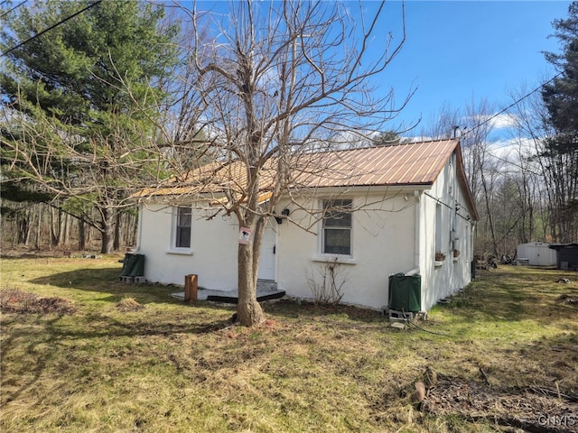 view of property exterior with stucco siding and a yard