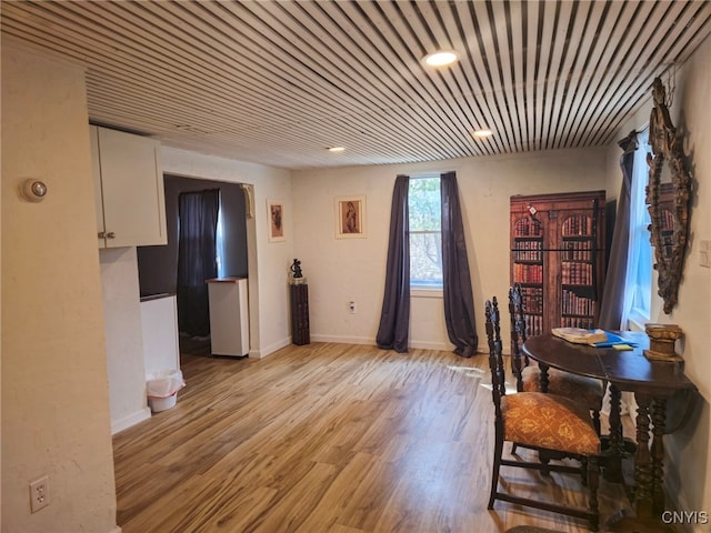 dining space featuring baseboards and light wood-type flooring