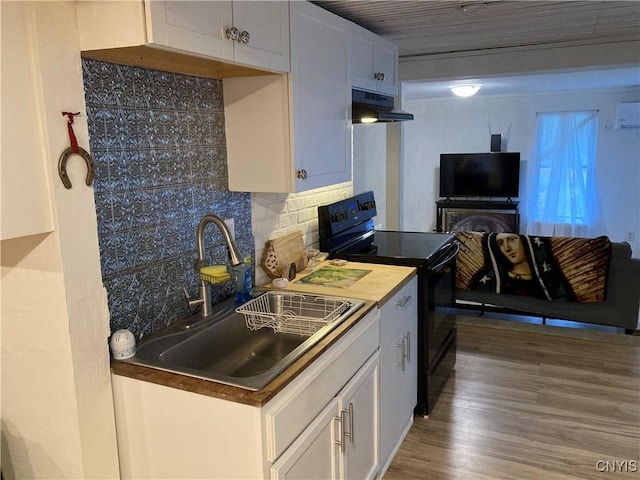 kitchen with decorative backsplash, black / electric stove, under cabinet range hood, white cabinetry, and a sink