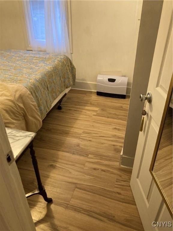 bedroom featuring baseboards and wood finished floors