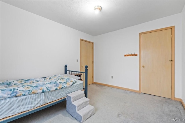 bedroom featuring light colored carpet and baseboards