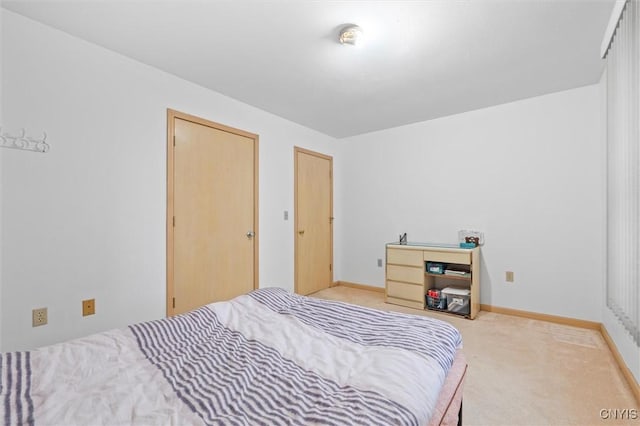 bedroom with light carpet and baseboards