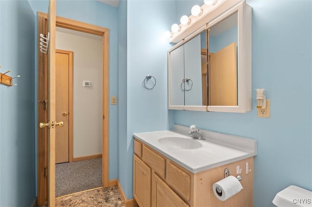 half bath with baseboards, toilet, and vanity