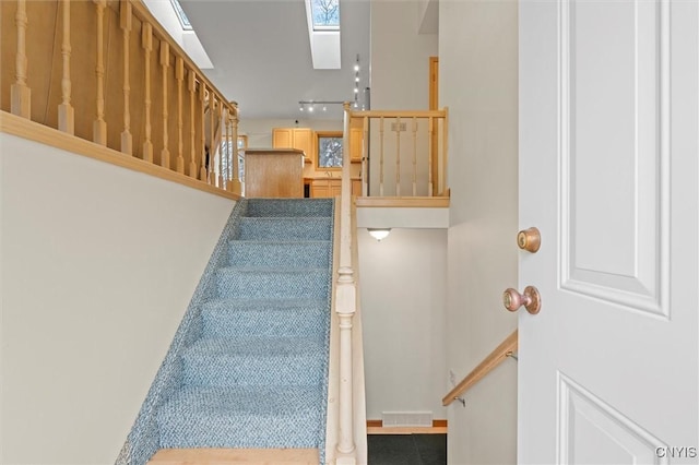 stairway with visible vents and a skylight