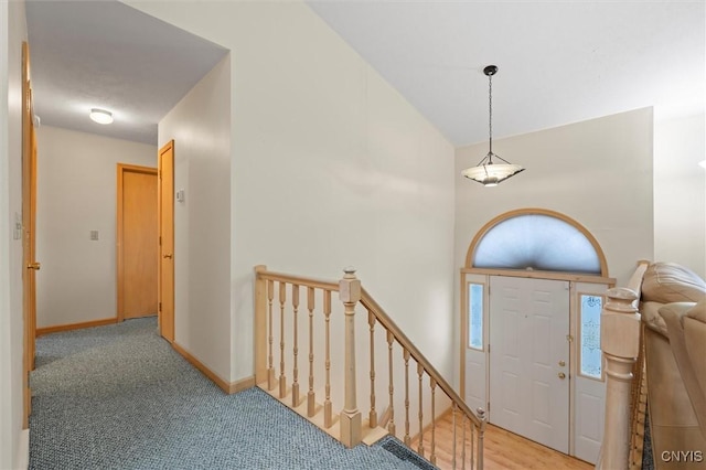 entrance foyer featuring light colored carpet and baseboards