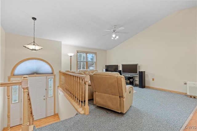 carpeted living area with baseboards, lofted ceiling, and a ceiling fan