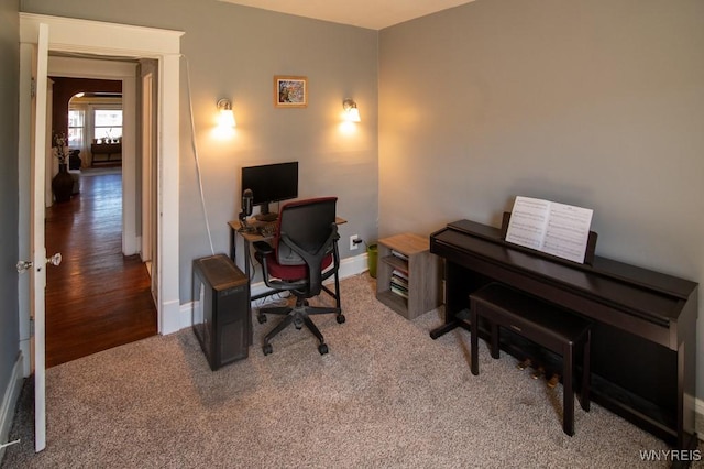 carpeted office with arched walkways and baseboards