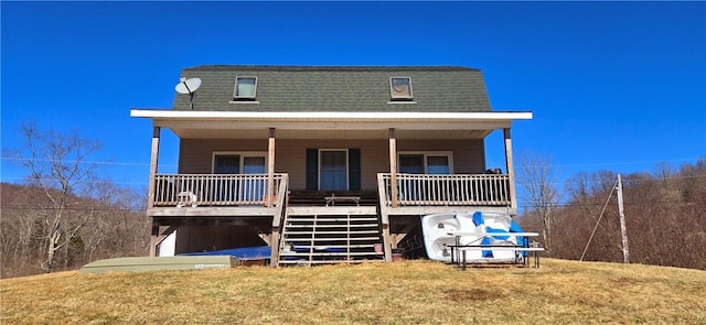 view of front facade featuring a front lawn, a porch, stairway, and roof with shingles