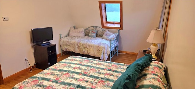 bedroom featuring baseboards and wood finished floors