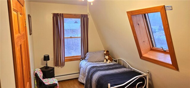 bedroom featuring a baseboard heating unit and wood finished floors