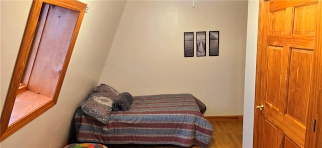 bedroom featuring baseboards and wood finished floors