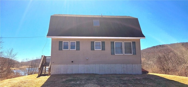 view of side of property featuring stairway and a lawn