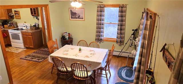 dining room with ceiling fan, light wood-style flooring, baseboard heating, and a wealth of natural light