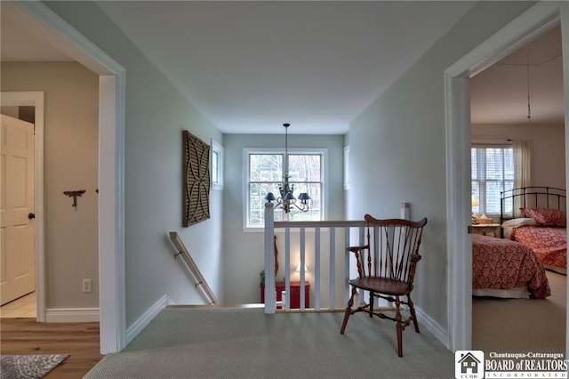 2401/2 Lakeside Dr, Ellery, NY 14712 - corridor featuring an upstairs landing, baseboards, an inviting chandelier, and wood finished floors