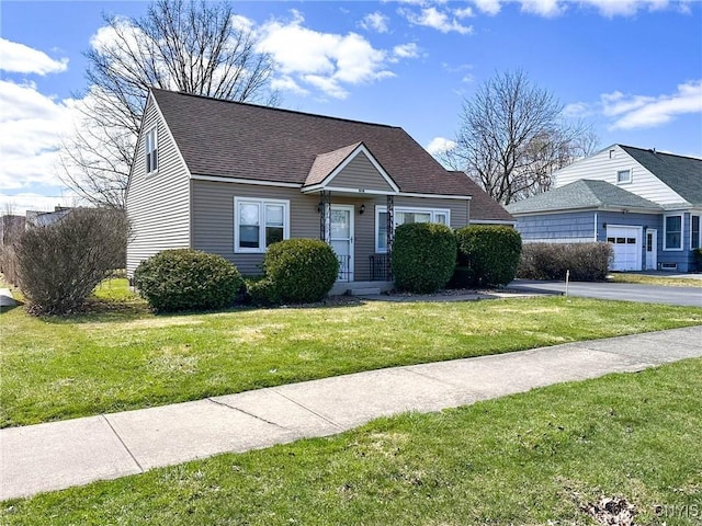 view of front facade featuring a shingled roof, aphalt driveway, and a front lawn