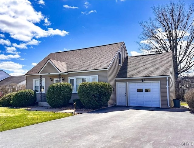 view of front of home with driveway, an attached garage, and roof with shingles