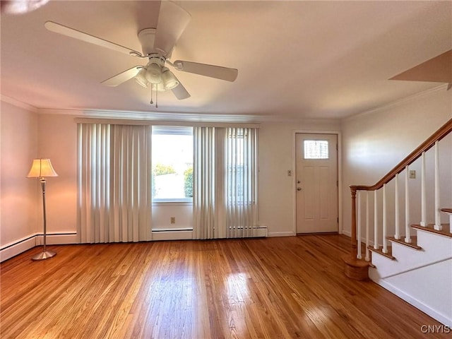foyer entrance featuring hardwood / wood-style flooring, baseboards, ornamental molding, stairway, and a ceiling fan
