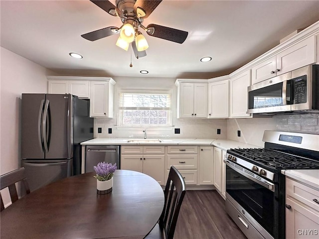 kitchen with white cabinets, a sink, stainless steel appliances, and tasteful backsplash
