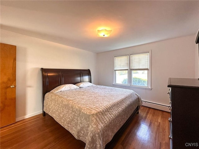 bedroom with baseboards, a baseboard heating unit, and dark wood-type flooring