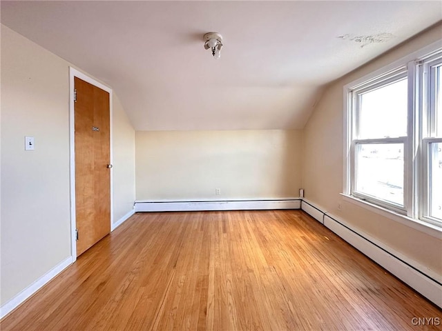 bonus room with light wood finished floors, baseboards, a baseboard radiator, lofted ceiling, and a baseboard heating unit