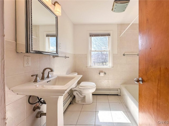 full bath with tile walls, toilet, a baseboard heating unit, and tile patterned floors