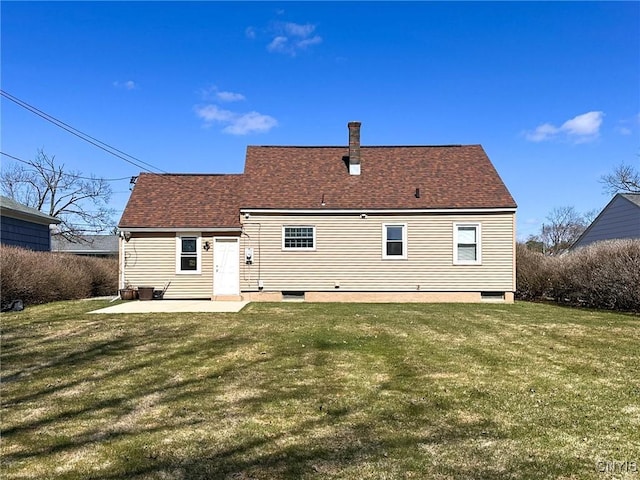 back of house with a lawn, a shingled roof, and a patio area