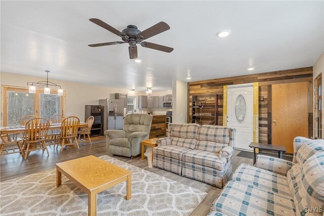 living area featuring recessed lighting, wood walls, light wood finished floors, and ceiling fan