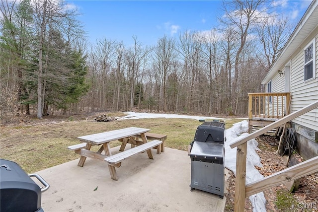 view of patio with outdoor dining space and a forest view
