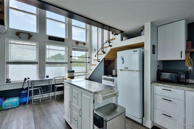 46337 Lake Of The Isle, Alexandria, NY 13607 - kitchen featuring black microwave, white cabinetry, and freestanding refrigerator