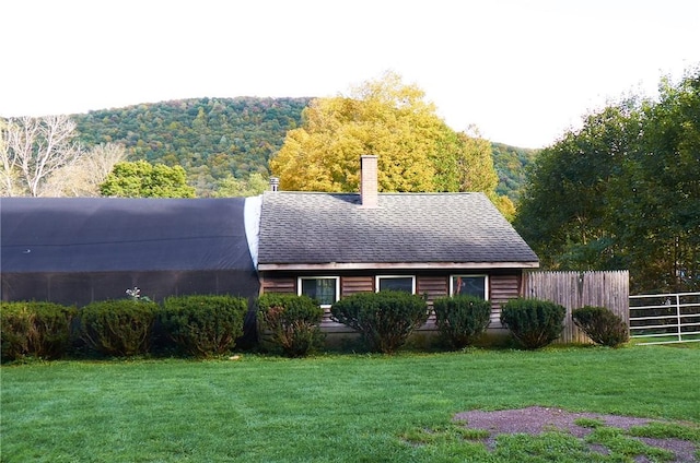 265 Main St, Delhi, NY 13753 - exterior space featuring a chimney, roof with shingles, fence, and a lawn