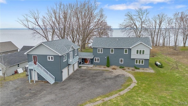20 Youman Rd, Constantia, NY 13028 - view of front of home with a water view, a shingled roof, dirt driveway, a front yard, and a garage