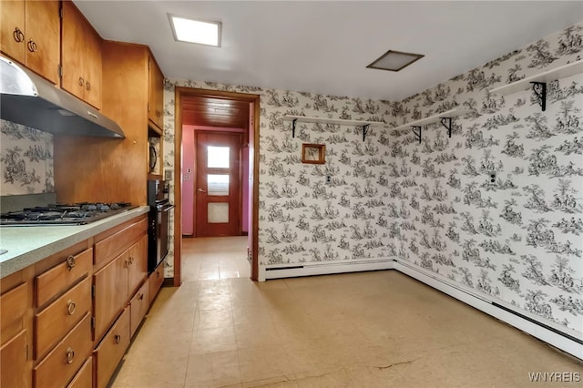 11765 Maple Ridge Rd, Shelby, NY 14103 - kitchen featuring stainless steel gas cooktop, brown cabinetry, under cabinet range hood, wallpapered walls, and black oven