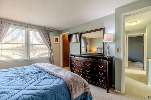 bedroom featuring baseboards and light colored carpet