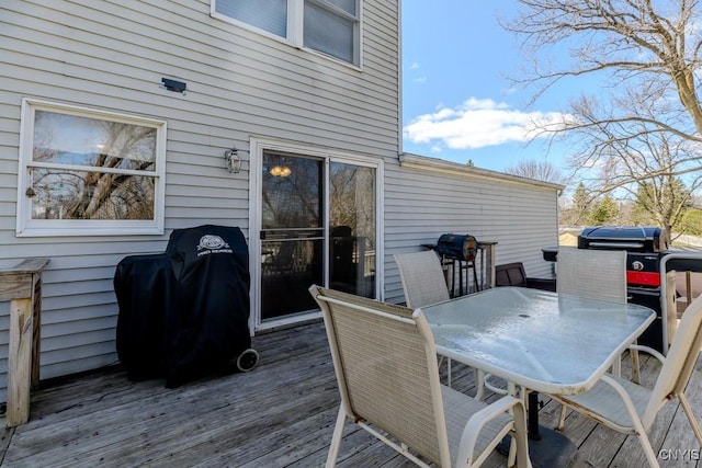 wooden deck with outdoor dining area and grilling area