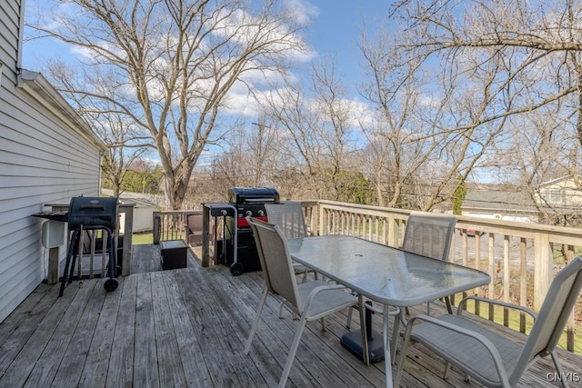 deck featuring outdoor dining area and grilling area
