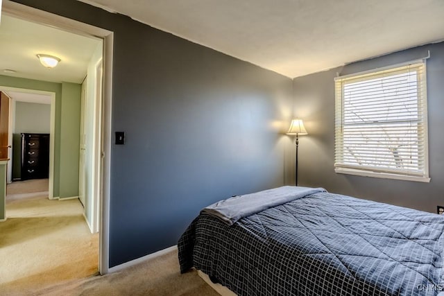 bedroom featuring light carpet and baseboards